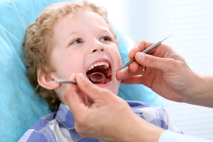 young boy in the dentist chair getting dental sealants