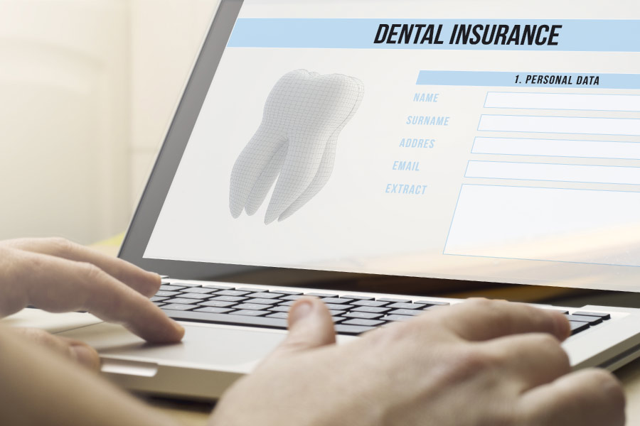 using a laptop to research dental insurance benefits