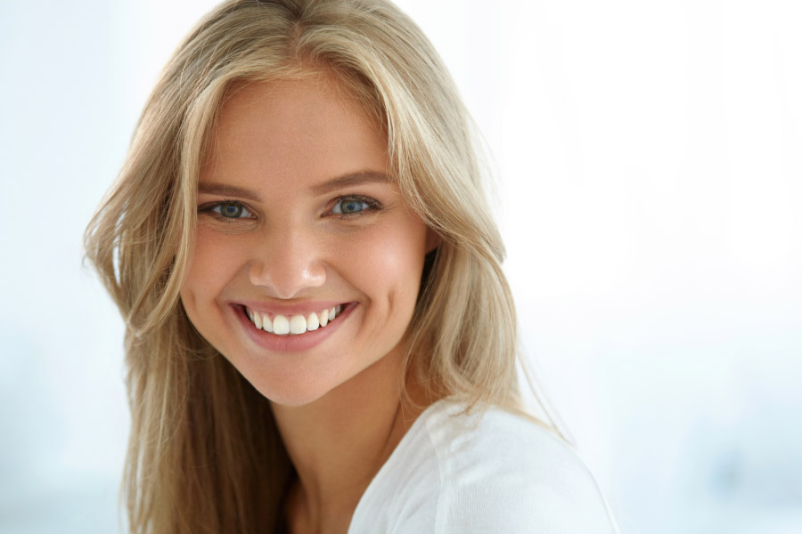young blond woman flashers her white teeth smile