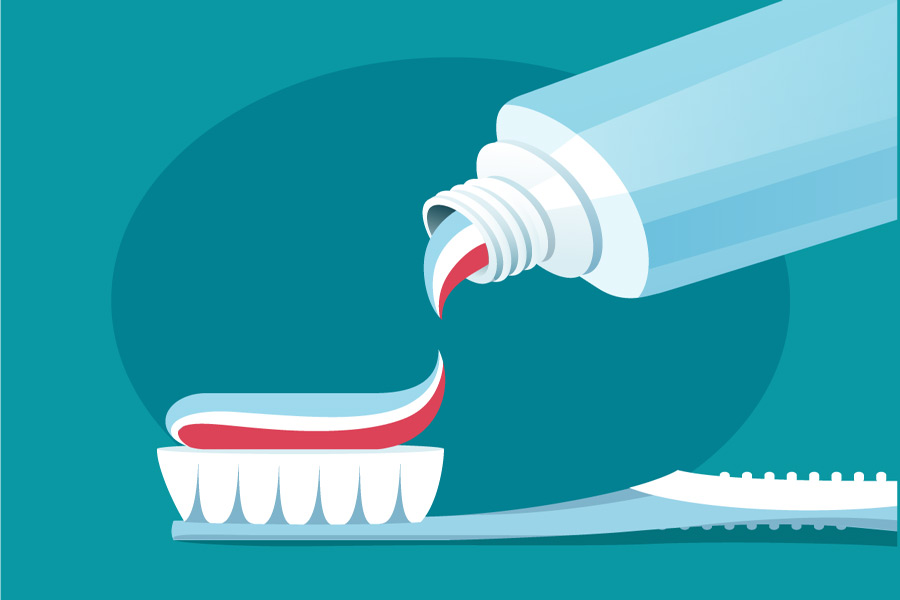 toothpaste being applied to a toothbrush