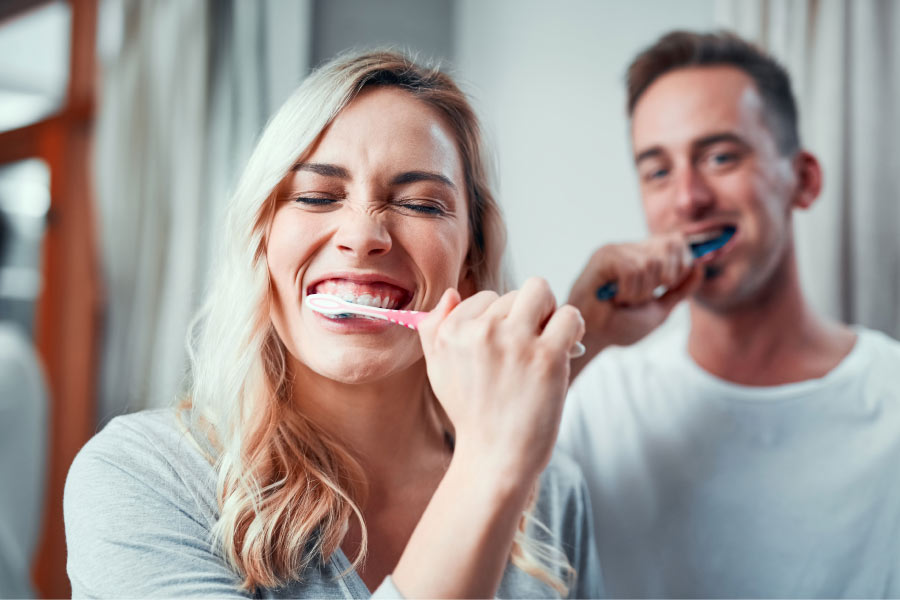 couple brush their teeth together