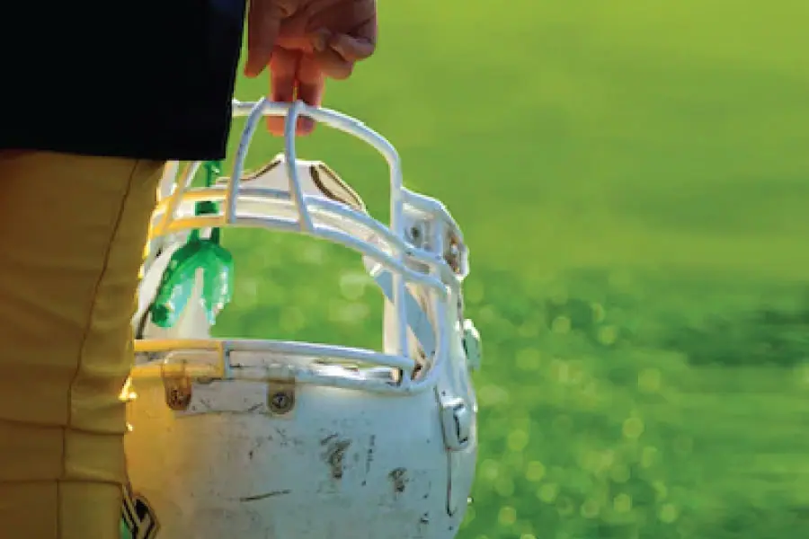 football helmet with a mouthpiece being carried by two fingers