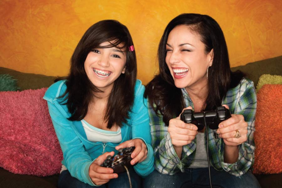 mother and teenage daughter play video games together